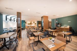 a restaurant with wooden tables and chairs at Occidental Vigo in Vigo