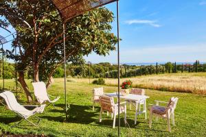 een witte tafel en stoelen in een veld bij Agriturismo Podere Gianmaria in Castiglioncello