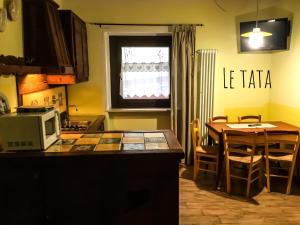 アオスタにあるChèvres à Cheval - Apartmentのキッチン(テーブル、電子レンジ、テーブル、椅子付)