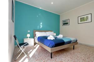 ein blaues Schlafzimmer mit einem Bett und einem Stuhl in der Unterkunft WATERCOLOURS NEAR ST PETER in Rom