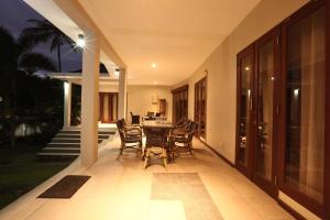 a dining room with a table and chairs on a patio at Villa Bel-Air in Senggigi