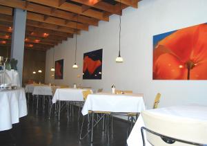 uma sala de jantar com mesas e cadeiras brancas em Hotel Central em Göttingen