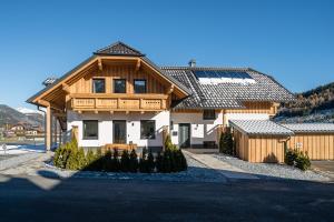 a large wooden house with a roof at Pistenblick in Sankt Margarethen im Lungau