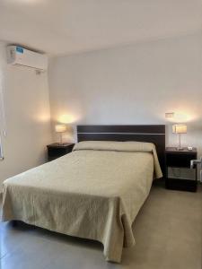 una camera da letto con un letto grande con due comodini di Complejo Las Rosas a Rafaela