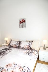 a bedroom with a bed with flowers on it at Apartman Aurora in Solde