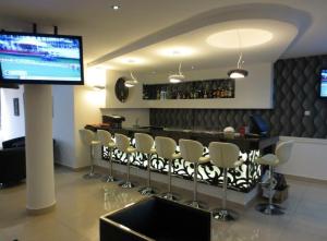 un bar en un restaurante con sillas y TV en Airport Plaza Hotel, en Yuba