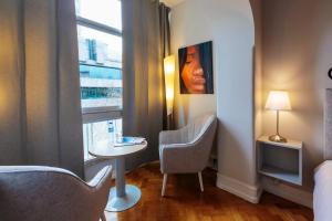 リスボンにあるMy Saldanha Suitesのテーブルと椅子、窓が備わる客室です。