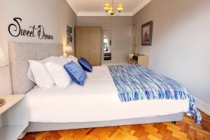 a bedroom with a large white bed with blue pillows at My Saldanha Suites in Lisbon