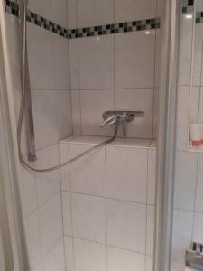 een badkamer met een douche en een glazen deur bij Standardzimmer nahe Messe und Airport in Düsseldorf