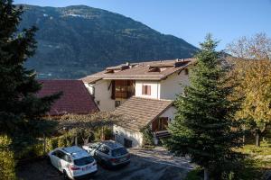 two cars parked in front of a house with a mountain at Unterdornerhof in Lagundo