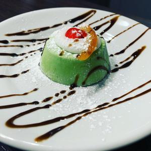 a green dessert on a white plate with chocolate sauce at B&B La Nuova Fattoria in Lizzano