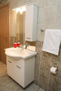 a bathroom with a white sink and a mirror at Apartman Aurora in Solde