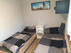 a bedroom with two beds and a tv on the wall at Haus Kanzler in Schwielochsee