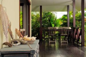 een veranda met stoelen en een tafel met een mand bij Casa El Tropico in Kralendijk