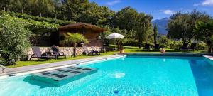 a swimming pool with a person sitting in a chair next to a house at Unterdornerhof in Lagundo