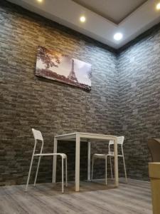 una mesa y sillas en una habitación con una pared de ladrillo en B2-homes, en Yanbu