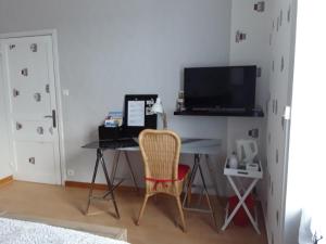 um quarto com uma secretária, um computador e uma cadeira. em Location Keransignour em Concarneau