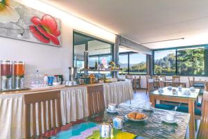 um restaurante com mesa, cadeiras e janelas em Hotel Valpolicella International em San Pietro in Cariano