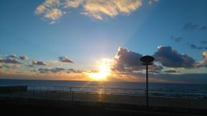 a sunset on the beach with the sun setting at Beach front sunset apartment in Apúlia +8 photos
