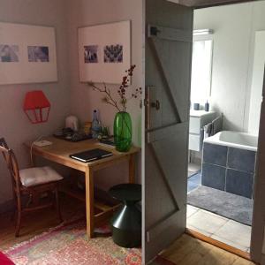 a room with a desk and a table with a door at La Colline des Renards Chambres in Locmaria-Berrien +52 photos