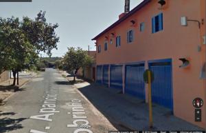 een lege straat naast een gebouw en een straatbord bij Casa di Angeli in Barretos