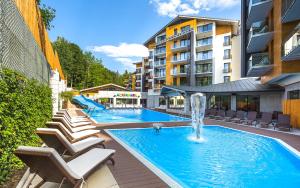 einen Pool mit Stühlen und einem Brunnen in einem Gebäude in der Unterkunft Blue Mountain Resort in Szklarska Poręba