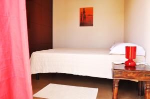 um quarto com uma cama e uma vela vermelha numa mesa em Lanita B&B em Càbras