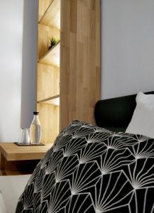 a bedroom with a bed with a black and white comforter at Hotel Nachtquartier in Weil der Stadt