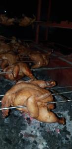 un montón de pollos están cocinando en un horno en Dam Dam Place, en San Vicente