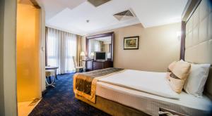 a bedroom with a large bed and a large window at CK Farabi Hotel in Ankara