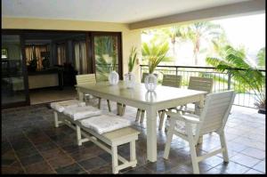 einen weißen Tisch und Stühle auf einer Terrasse in der Unterkunft Mahogany Villa in Ballito