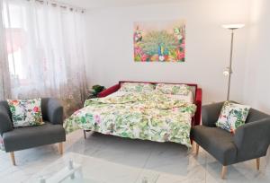 1 dormitorio con 1 cama y 2 sillas en Loft Orchidee 2 en Überlingen