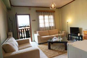 a living room with a couch and a table at Small Town Apartment in Konitsa
