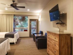 Habitación de hotel con cama y TV de pantalla plana. en Driftwood Lodge, en Springdale