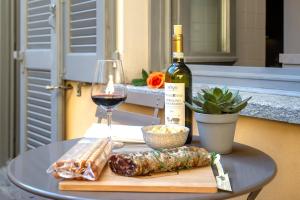 a table with a bottle of wine and a glass at Vanessa Apartment in Como