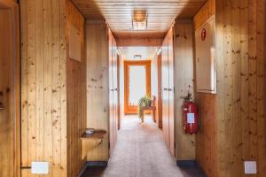 un corridoio con pareti rivestite in legno e un estintore di Hotel Burgener a Saas-Fee