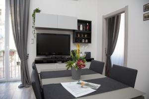 ナポリにあるPalazzo Mormando - Modern Apartmentのリビングルーム(テーブル、テレビ付)