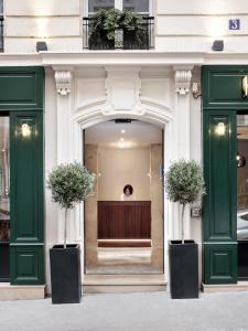 a woman standing in the window of a building at New Hotel Le Voltaire in Paris