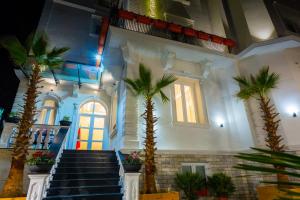 a lobby with palm trees and stairs in a building at ART Hotel Tirana in Tirana