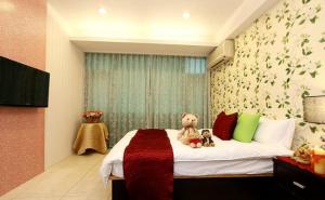 two teddy bears sitting on a bed in a bedroom at Simplicity Sojourn Hualien in Hualien City
