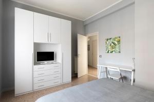 een slaapkamer met een bed, een bureau en een televisie bij Enjoy Porta Furba in Rome