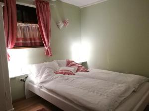 a bedroom with a bed with white sheets and a window at Elbhangzimmer Dresden in Dresden