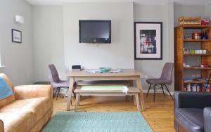 a living room with a table and a tv at Comfortable Waterloo Home Near Thames in London