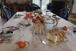 a table with a table cloth with bread and glasses at Chateau du Guérinet D'Orchaise in Orchaise