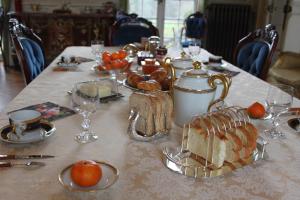 einen Tisch mit einem Tischtuch mit Brot und Gläsern in der Unterkunft Chateau du Guérinet D'Orchaise in Orchaise