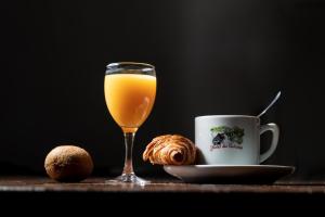 Chez Bouchet في Licq-Athérey: كوب من عصير البرتقال بجانب كوب من القهوة
