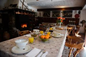 a table with plates and bowls of oranges and a fireplace at Crêmerie Balmat in Chamonix