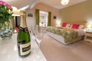 a bottle of wine sitting on a bed in a hotel room at Ty Derw Country House in Dinas Mawddwy
