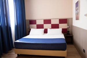 a bedroom with a bed with a red and white headboard at iH Hotels Milano St. John in Sesto San Giovanni