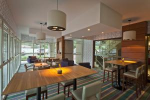 a dining room with tables and chairs and windows at Bourbon Residence Barra da Tijuca - Rio de Janeiro in Rio de Janeiro